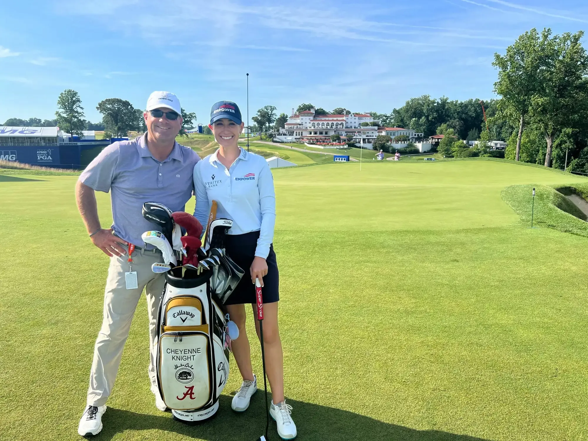 Joey Wuertemberger and Cheyenne Knight standing beside her golf bag on a fairway, with a clubhouse in the distance